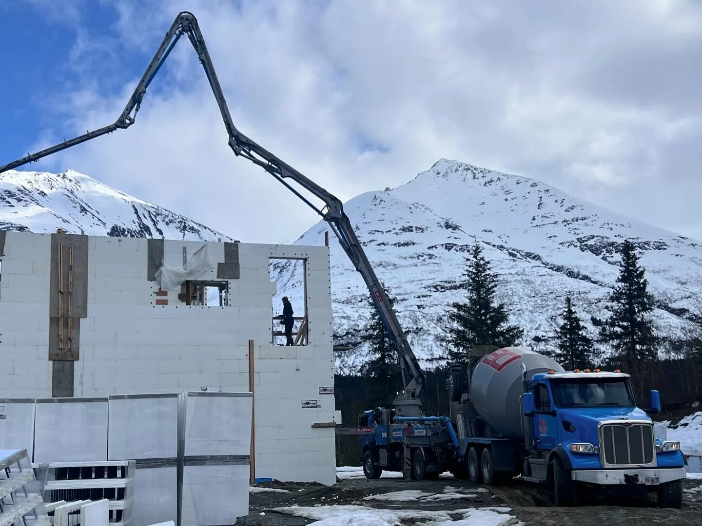 Davis Block pump truck and ICF wall construction against snow-capped Alaska mountains